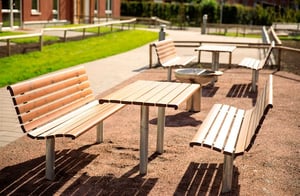 Innergård med utemöbler i solen, med bänkar och bord på innergård