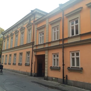 Fasad på ett orange flerbostadshus med många fönster och en gångport