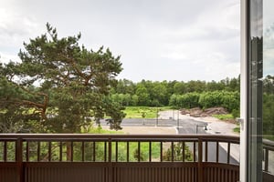 Inflyttningsklar lägenhet med utsikt från balkong mot grönområde och väg