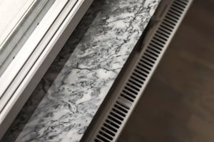 Fönsterbräda i marmormönster med ventilationsgaller intill
