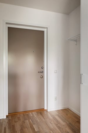 Inflyttningsklar lägenhet med ljus hall, vitmålade väggar och trägolv