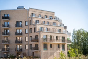 Flerbostadshus med balkonger i ljus tegelarkitektur