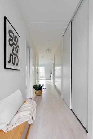 Inflyttningsklar lägenhet med ljus hall, vita väggar och ljus trägolv