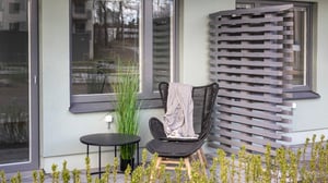 Inflyttningsklar uteplats med stol, bord, växt och fasad med fönster