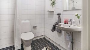 Inflyttningsklart badrum med vitt kakel, wc och handfat