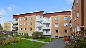 Lägenhetshus med grön innergård och gångväg