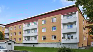 Flerbostadshus med tegel фасad och balkonger