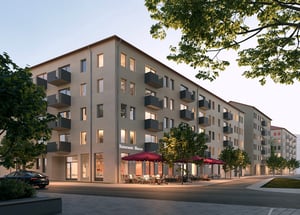 Nyproducerade lägenhetshus med balkonger, träd längs gatan och restaurang i gatuplan