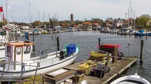 Båtar i en småbåtshamn med bryggor, master och vatten i Helsingborg