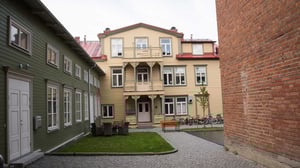 Innergård med gräsytor, cyklar och flerbostadshus i trä och puts