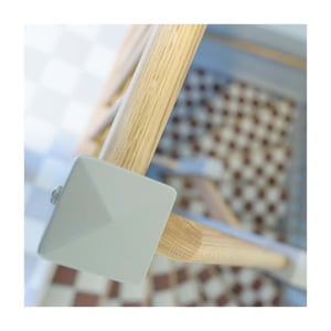 Träräcke i trappa med ljusmålad detalj och mönstrat golv i bakgrunden