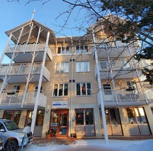 Flerbostadshus med balkonger och entré i vintermiljö