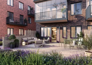 Lägenhet med stor uteplats, sittgrupp, matbord och omgivande bostadshus i tegel