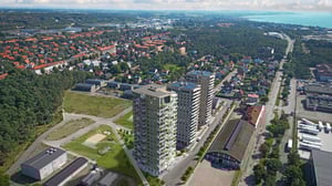 Flygbild över ett bostadsområde med höghus, villor, grönområden och vägar