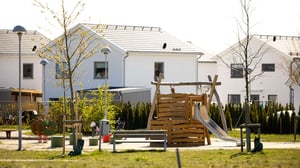 Lekplats i ett bostadsområde med radhus i bakgrunden