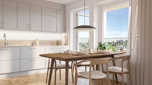 Köks- och matrum i ljusa färger med träbord, stolar och stora fönster. Inflyttningsklart