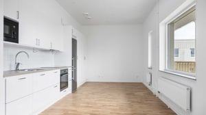 Inflyttningsklar lägenhet med vitt kök, ekgolv och stort fönster