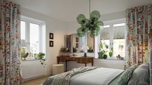 Sovrum med vita väggar, stora fönster, färgglada blommiga gardiner och en retro skrivbord med spegel. Gröna växter och en modern taklampa kompletterar inredningen