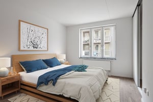 Sovrum med dubbelsäng, sängbord, fönster och garderob med skjutdörrar