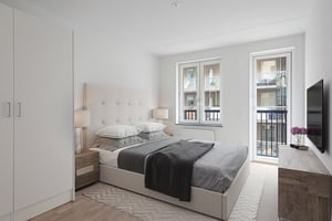 Sovrum med dubbelsäng, garderob och stora fönster