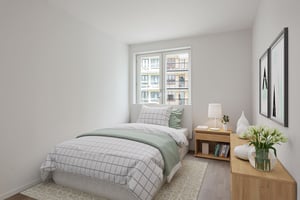 Inflyttningsklart sovrum med enkelsäng, fönster och ljus inredning