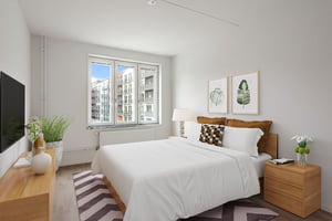 Inflyttningsklart sovrum med dubbelsäng, fönster och moderna möbler