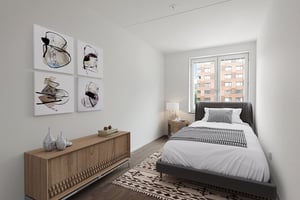 Inflyttningsklart sovrum med enkelsäng, fönster, sideboard och väggkonst