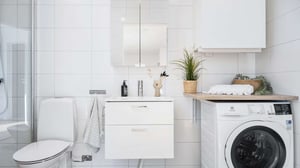 Badrum med toalett, handfat, spegelskåp och tvättmaskin