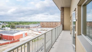 Balkong med utsikt över byggarbetsplats och bostadshus