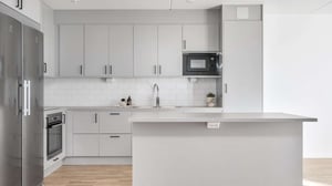 Inflyttningsklar lägenhet med ljus, modern köksinredning, vita skåp och köksö