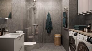Modernt badrum med duschhörna, tvättmaskin och torktumlare samt grå kakelväggar