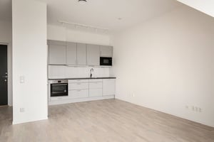 Inflyttningsklar lägenhet med ljus öppen planlösning och kök i grått och vitt