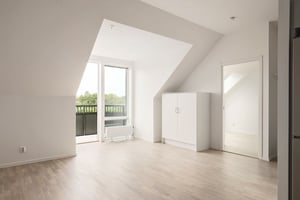 Inflyttningsklart rum med ljusa väggar, stort fönster och balkongdörr