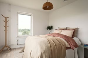 Inflyttningsklar lägenhet med sovrum, stor säng, fönster och ljusa väggar