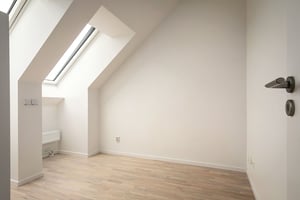 Inflyttningsklar lägenhet med ljusa väggar, trägolv och takfönster