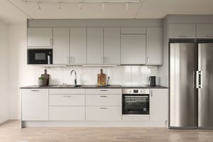 Inflyttningsklart kök med ljusa skåpluckor, rostfri kyl och ugn