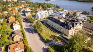 Flygvy över bostadsområde med lägenhets- och villabebyggelse vid en sjö
