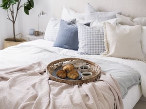 Bäddad säng, kuddsamling, frukostbricka med croissanter och kaffe