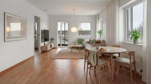 Inflyttningsklar lägenhet med ljusa rum, trägolv och möblerad matplats vid stora fönster