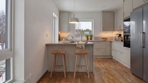 Inflyttningsklar lägenhet med modernt kök, köksö och två barstolar