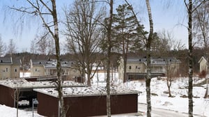 Bostadsområde med flerfamiljshus, garage och höga träd