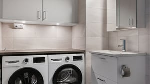 Inflyttningsklar tvättstuga med tvättmaskin, torktumlare och handfat