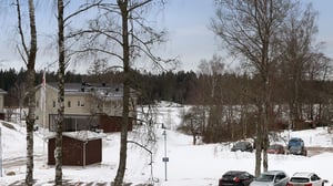Vintermiljö med hus, träd och parkerade bilar