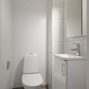 Inflyttningsklart wc med vitt handfat, spegelskåp, toalett och spegelskåp