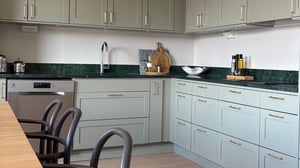 Inflyttningsklar lägenhet med modernt kök, gråa skåp, mörk bänkskiva och integrerad diskmaskin