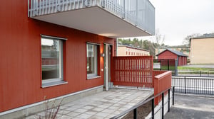 Röd fasad, balkong och uteplats
