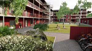 Bostadsgård med röda flerbostadshus, grönskande innergård, cyklar och personer som sitter på gräsmattan