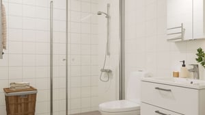 Badrum med dusch, toalett och handfat i ljusa material