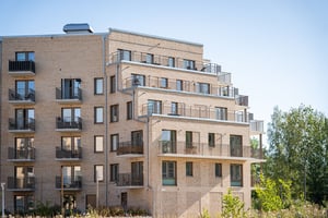 Flerbostadshus med balkonger i ljus tegelarkitektur