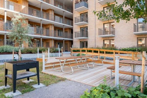 Innergård med grill, picknickbord och balkonger i ett flerbostadshus